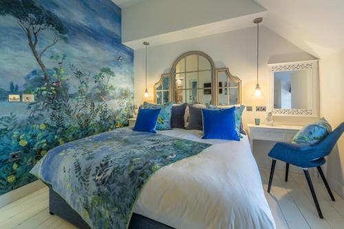索海姆No33 THORNHAM BOUTIQUE COTTAGE 2的一间卧室配有一张带蓝色枕头的大床