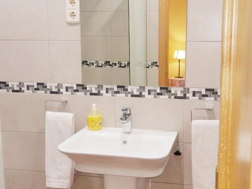 马德里Hostal Puerta Bonita Vista Alegre的白色的浴室设有水槽和镜子