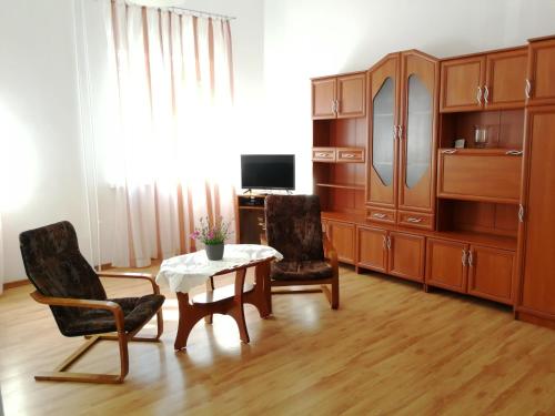 库多瓦-兹德鲁伊Apartament Jaśminowy的客厅配有木制家具和桌椅