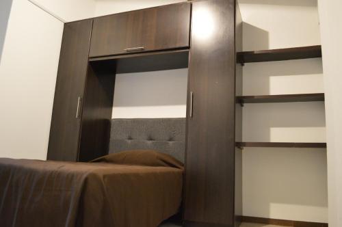波帕扬Apartaestudio San Nicolas的一间卧室配有带架子的大型木制橱柜