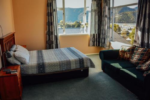 哈夫洛克布鲁姆恩旅馆的一间卧室配有一张床、一张沙发和一个窗口