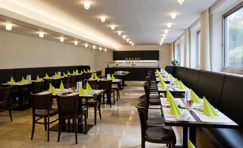 斯图加特Akademie der Dioezese的用餐室配有桌椅和黄色餐巾