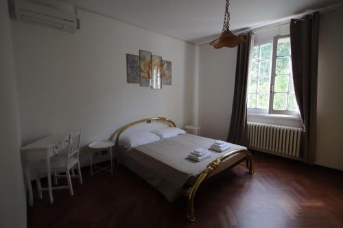 萨维奥迪拉韦纳La Casa nel Bosco的一间卧室配有一张床、一张桌子和一个窗户。