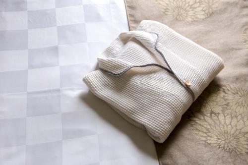 高松高松东急REI酒店的睡床上的白色布巾纸
