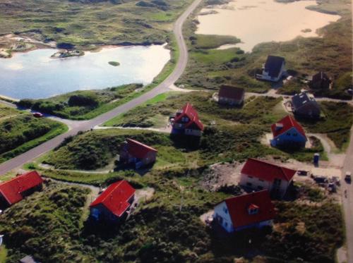 Midsland aan Zee't Zeepaardje的享有小岛的空中景色,设有房屋和道路