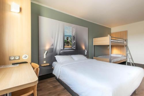 瓦讷B&B HOTEL Vannes Ouest Golfe du Morbihan的一间卧室配有一张床和一张双层床。