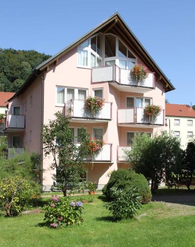 巴特尚道Hotel-Garni Elbgarten Bad Schandau的一座粉红色的建筑,阳台上放着花盒