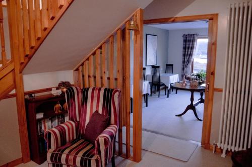 洛欣弗达瓦尔住宿加早餐旅馆的客厅设有楼梯、椅子和桌子