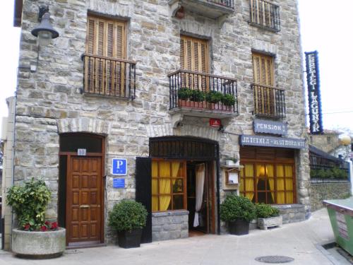 扎鲁亚斯Pensión Lagunak的一座石制建筑,有门窗和植物