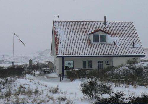 Midsland aan Zee't Zeepaardje的雪覆盖的屋顶房屋