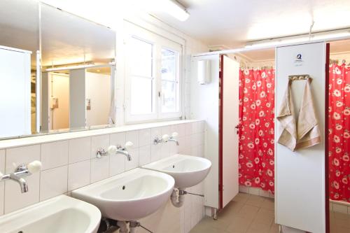 吉梅尔瓦尔德格美湾德山地旅馆的浴室设有两个盥洗盆和红色的淋浴帘