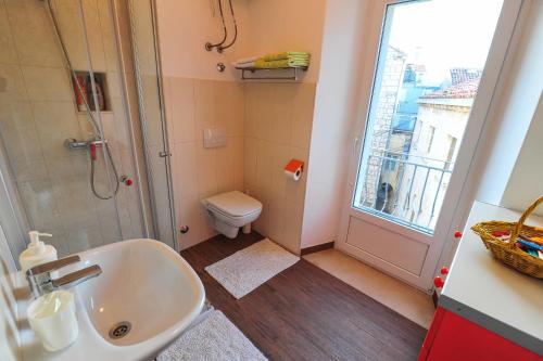科尔丘拉Apartment Punat的一间带水槽和卫生间的浴室以及窗户。