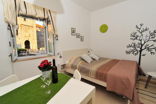 科尔丘拉Apartment Punat的一间卧室配有一张床、一张桌子和一个窗户。