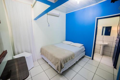 波多韦柳Hotel Cielo的一间卧室设有蓝色的墙壁和一张床