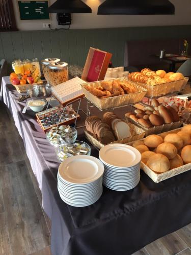 MeliskerkeHotel bij Boone的一张桌子,上面放有盘子、糕点和面包