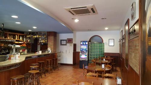 圣地亚哥－德孔波斯特拉圣雅各布酒店的一间带桌椅的餐厅和一间酒吧