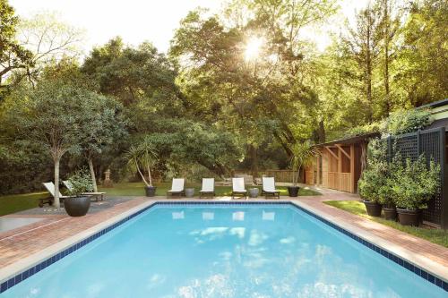 格伦艾伦Gaige House的庭院内的游泳池,带椅子和树木
