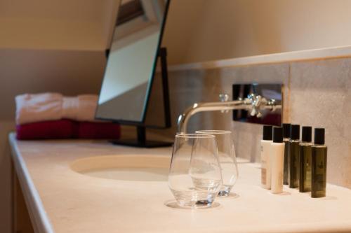 斯图泽姆拉麦森都提格瑞公寓酒店的浴室水槽设有饮用玻璃和水龙头