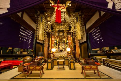 高山Temple Hotel Takayama Zenkoji的大房间天花板上挂着红色的弓