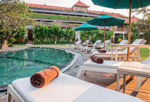 勒吉安阿斯塔基纳Spa酒店的毗邻度假酒店的带椅子和遮阳伞的游泳池