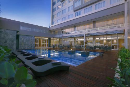 外南梦ASTON Banyuwangi Hotel and Conference Center的一座大型建筑,前面设有一个游泳池