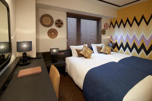 大阪DEL style Osaka Higashi Temma by Daiwa Roynet Hotel的一间卧室配有一张床和一张书桌及电视