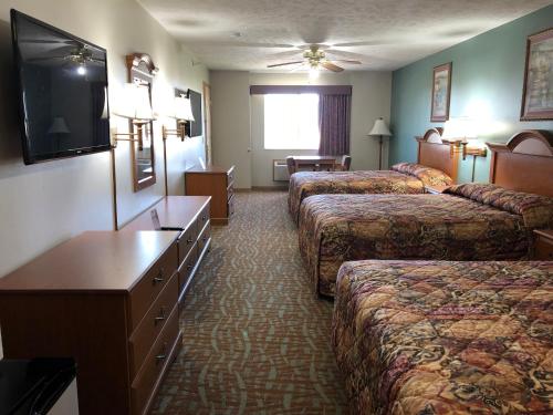 奥马哈奥马哈乡村酒店的一间酒店客房,设有三张床和一台平面电视
