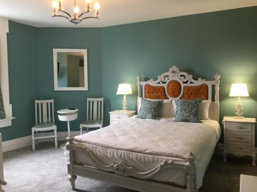 约尔Abbey View House的一间卧室配有一张蓝色墙壁的床和两把椅子