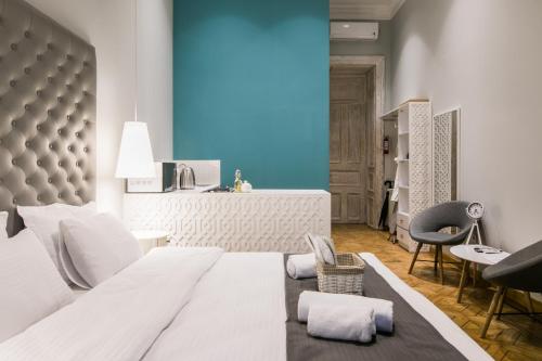 第比利斯Kuxos Machabeli 1 Studio的卧室配有一张白色大床和一把椅子