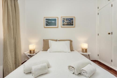 拉戈斯Lagos Apartamento Praia Dona Ana的卧室配有带两盏灯的白色床