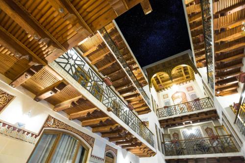 布哈拉萨菲亚精品酒店的一座铺有木地板的建筑和配有灯光的阳台