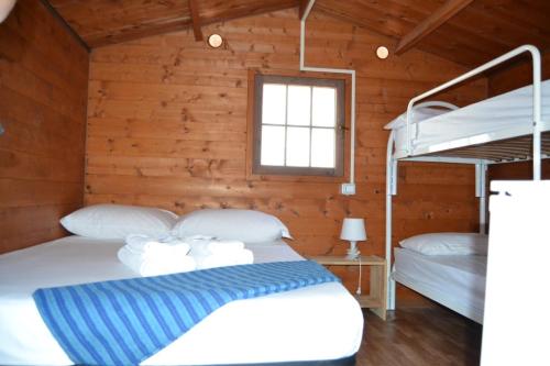 波利科罗Policoro Village Hotel的小屋内设有一间带两张双层床的卧室