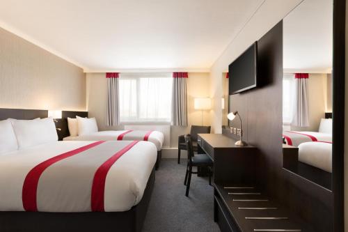 乔利华美达乔利南酒店的酒店客房配有两张床、一张书桌和一张书桌