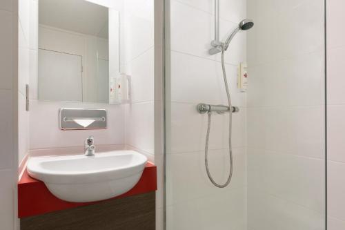 乔利华美达乔利南酒店的白色的浴室设有水槽和淋浴。