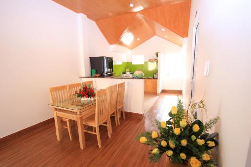 大叻Moc Tra Hotel的厨房以及带桌椅的用餐室。