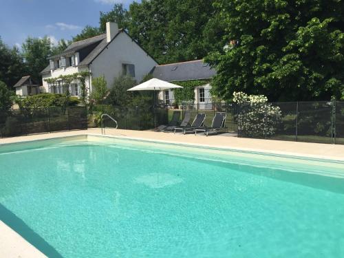 Blaison拉布特高赫尔住宿加早餐旅馆的一座大蓝色游泳池,位于房子前