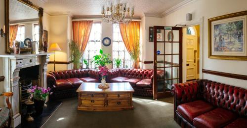 奇德尔Pymgate Lodge Hotel Manchester Airport的客厅配有真皮沙发和茶几