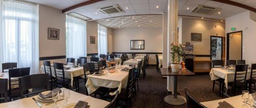 卢尔德山堡酒店的用餐室配有白色的桌椅和桌面