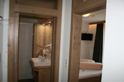 伯恩鲍姆阿尔分霍夫思琪那纳酒店的一间带水槽、淋浴和镜子的浴室