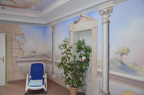 加尔米施-帕滕基兴莱茵酒店的一间设有蓝色椅子和壁画的房间