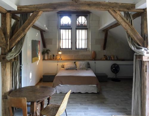 Faverolles-sur-Cherstudio avec terrasse Abbaye d'Aiguevive的卧室配有床、桌子和窗户。