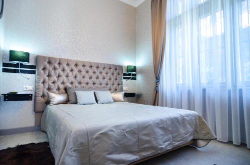 布达佩斯Viktoria Luxury Apartment的一间卧室设有一张大床和一个大窗户