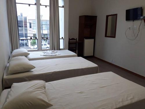 ItabaianaHotel Danubio的带大窗户的客房内的三张床