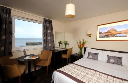 布罗德福德都诺丽酒店‘定制酒店’的酒店客房设有床、桌子和窗户。
