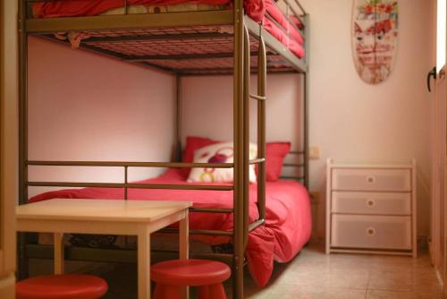 莫甘Casa Apolo的一间卧室配有两张双层床、一张桌子和凳子