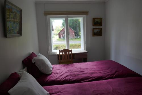 凯尔德拉Kärdla Holiday House的一间卧室设有紫色的床和窗户