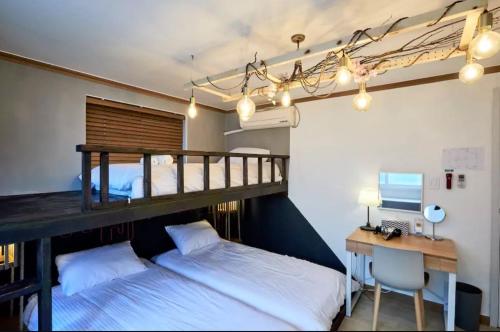 首尔楚尔旅馆的一间卧室设有两张双层床和一张带电脑的书桌