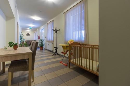 小克勒什Tölgyfa Vendégház的一间设有一张婴儿床和一张桌子的房间和一间房间