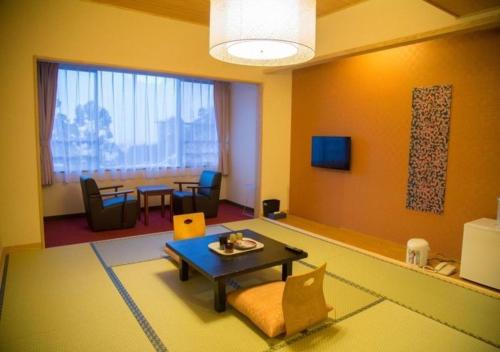 会津若松东山公园新风月酒店的一间带桌子的客厅和一间餐厅