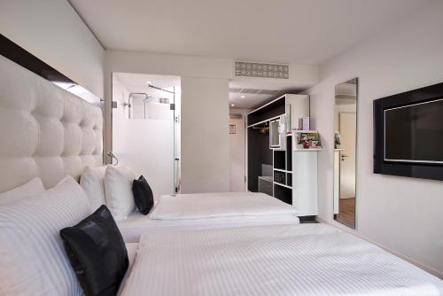 亚琛INNSiDE by Meliá Aachen的一间卧室配有两张床和一台平面电视